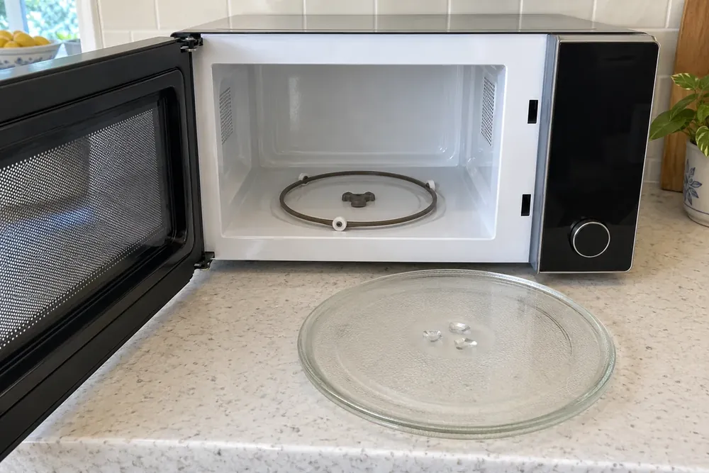 Open countertop microwave with glass plate removed, exposing roller ring and central drive coupler